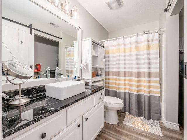 bathroom with vanity, hardwood / wood-style flooring, a textured ceiling, and toilet