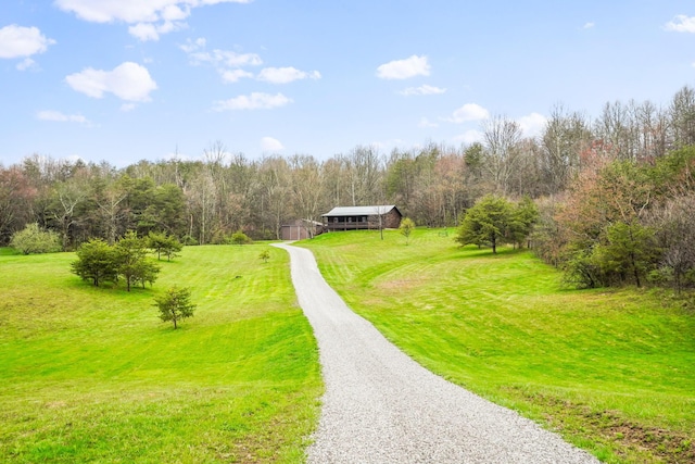 view of home's community with a rural view, a lawn, and an outdoor structure