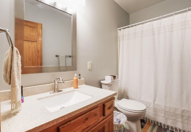 bathroom with vanity, toilet, and curtained shower