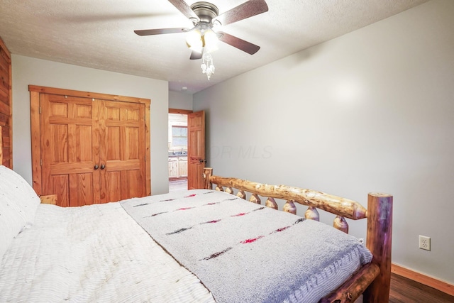 bedroom featuring ceiling fan, dark hardwood / wood-style floors, a closet, and a textured ceiling