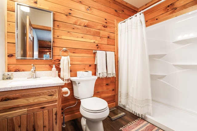 bathroom with toilet, wood walls, vanity, a shower with shower curtain, and hardwood / wood-style floors