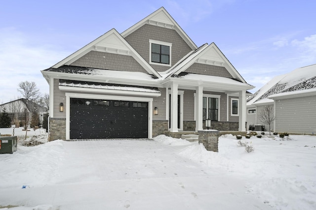 view of front facade with a garage, cooling unit, and stone siding