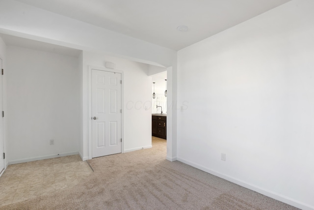 carpeted spare room featuring sink