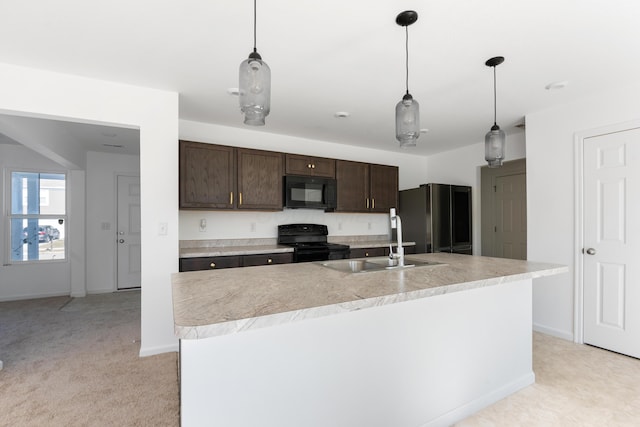 kitchen featuring sink, hanging light fixtures, a kitchen island with sink, black appliances, and dark brown cabinets