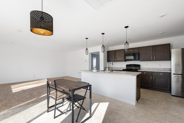 kitchen with sink, hanging light fixtures, dark brown cabinets, black appliances, and a center island with sink