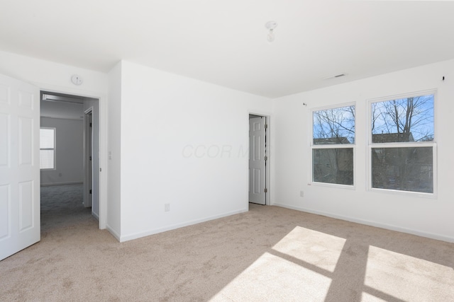 empty room featuring plenty of natural light and light carpet