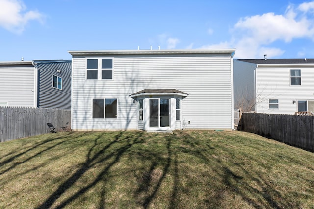 back of house with a lawn