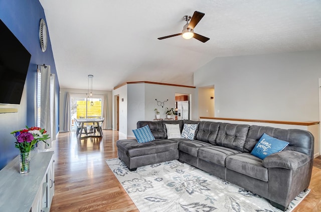 living room featuring vaulted ceiling, ceiling fan, and light hardwood / wood-style flooring