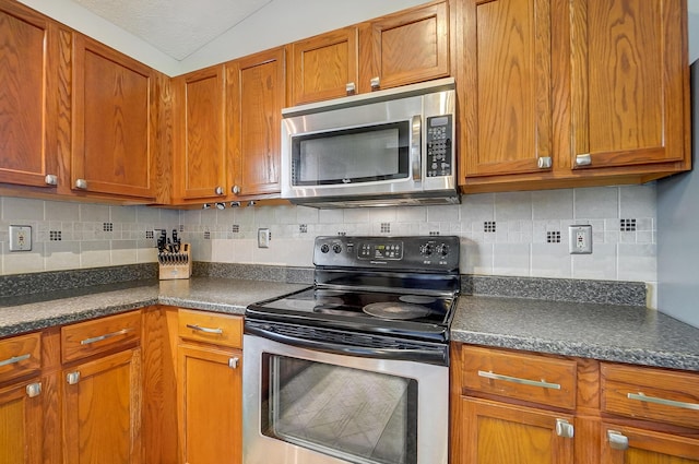 kitchen featuring backsplash, vaulted ceiling, and appliances with stainless steel finishes