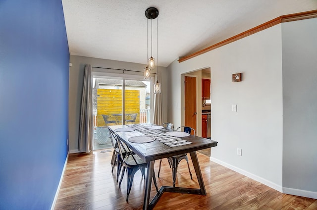 dining room featuring a textured ceiling and light wood-type flooring