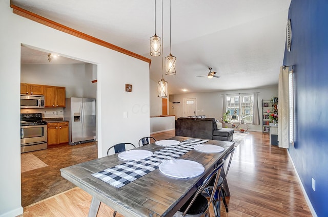 dining space with crown molding, ceiling fan, and light hardwood / wood-style flooring