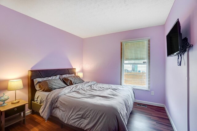 bedroom featuring dark wood-type flooring and a textured ceiling