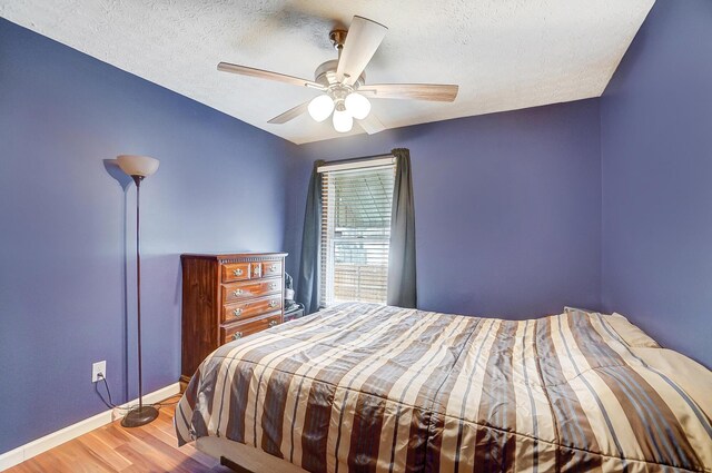 bedroom with wood-type flooring, ceiling fan, and a textured ceiling