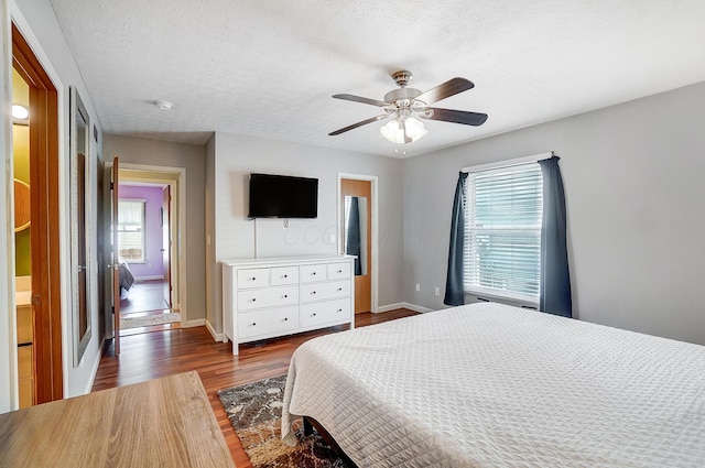 bedroom with ceiling fan, dark hardwood / wood-style floors, and a textured ceiling