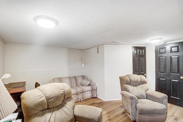 living room featuring a textured ceiling and light hardwood / wood-style floors