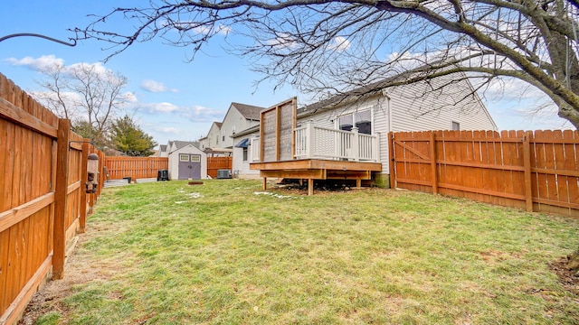 view of yard with a wooden deck, central AC unit, and a storage shed