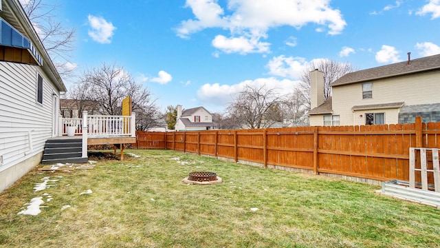 view of yard with a wooden deck and a fire pit