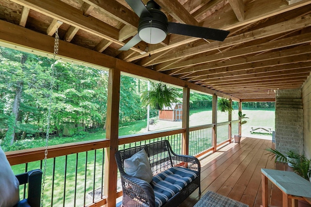 wooden terrace with ceiling fan and a lawn