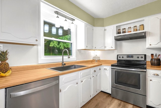 kitchen with sink, white cabinetry, a textured ceiling, light wood-type flooring, and stainless steel appliances