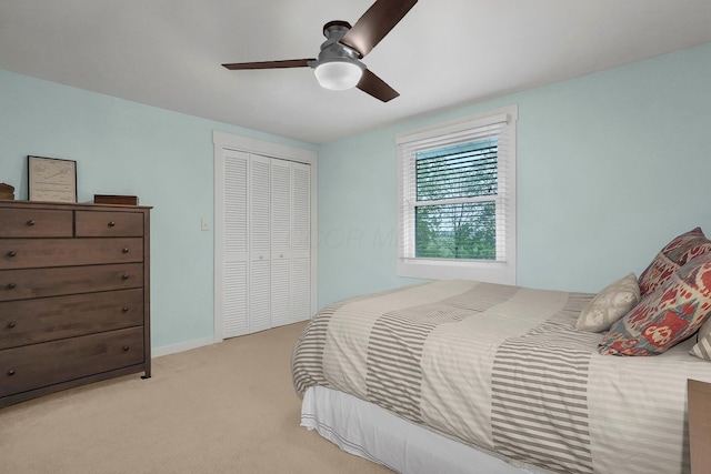 bedroom with light carpet, ceiling fan, and a closet