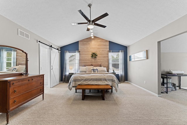 bedroom featuring multiple windows, light carpet, visible vents, and a barn door