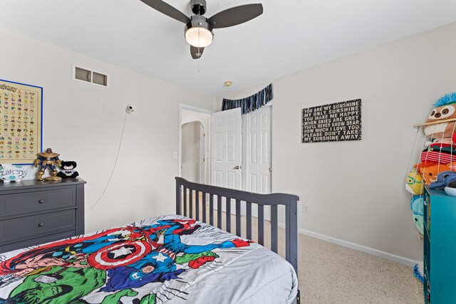 carpeted bedroom with baseboards, a ceiling fan, and visible vents