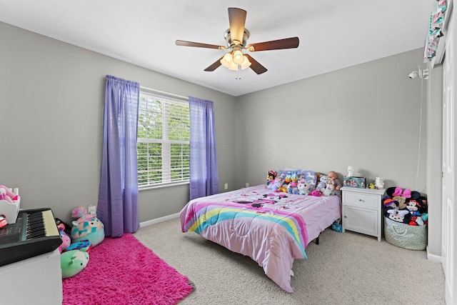 bedroom featuring light colored carpet, baseboards, and a ceiling fan