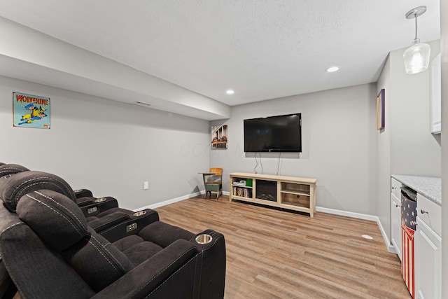 living room with light wood-style flooring, baseboards, recessed lighting, and a textured ceiling