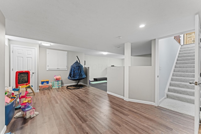 recreation room with baseboards, wood finished floors, and recessed lighting