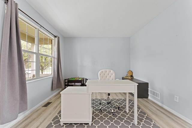 office space with light wood finished floors, baseboards, and visible vents