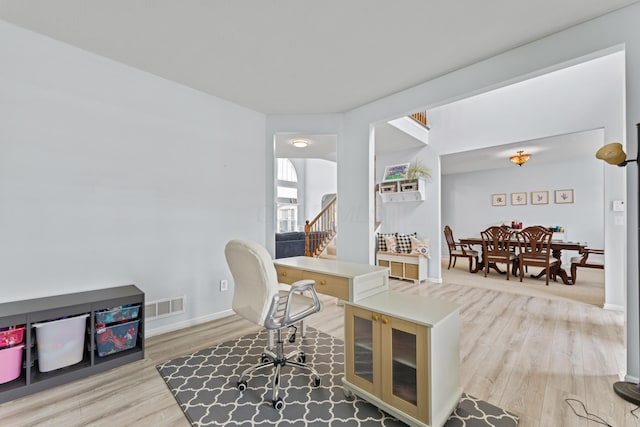office featuring baseboards, visible vents, and light wood-type flooring