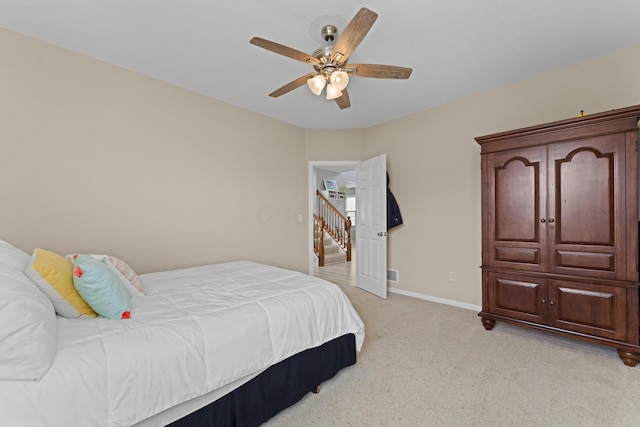 bedroom with light carpet, a ceiling fan, and baseboards