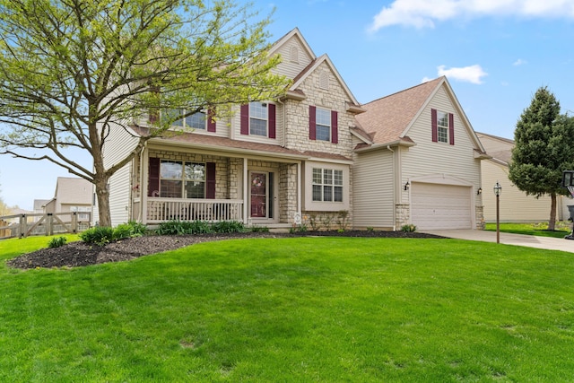 view of front of home featuring an attached garage, driveway, covered porch, stone siding, and a front yard