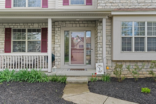 property entrance featuring a porch and stone siding