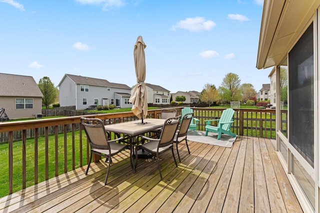 deck with a lawn, a residential view, and outdoor dining space