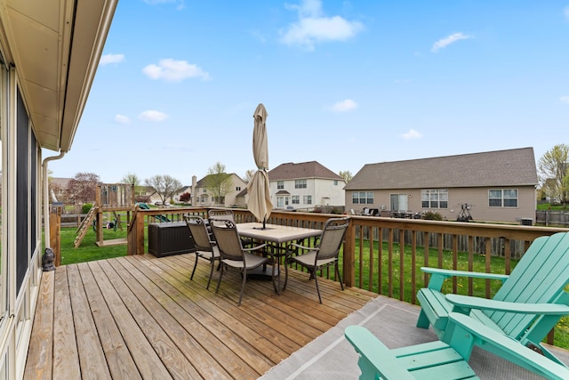 deck with a lawn, a residential view, and outdoor dining space