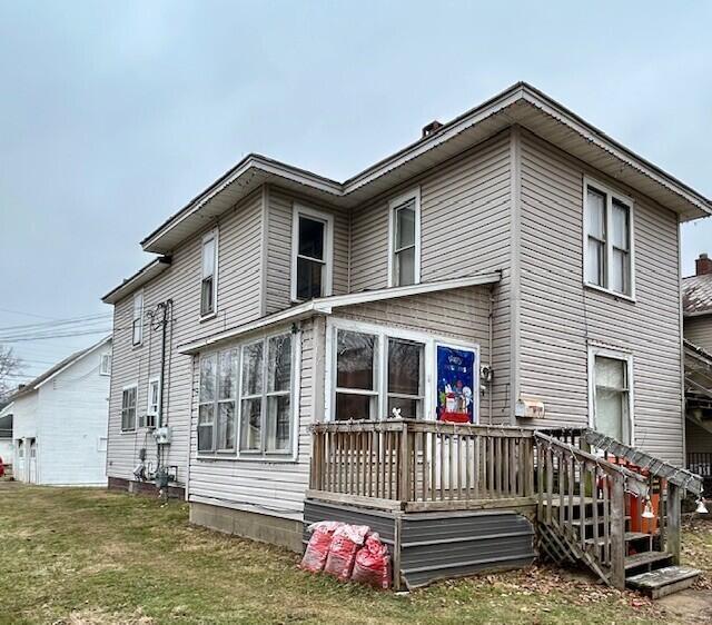 rear view of house featuring a lawn and a wooden deck