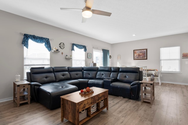 living room featuring ceiling fan, a healthy amount of sunlight, and light wood-type flooring