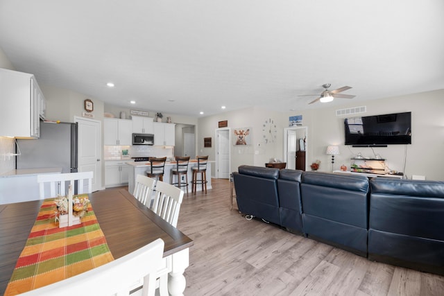 dining room with ceiling fan and light wood-type flooring