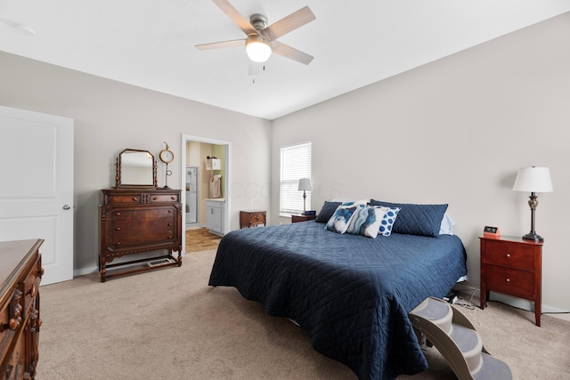 bedroom featuring light carpet, connected bathroom, and ceiling fan