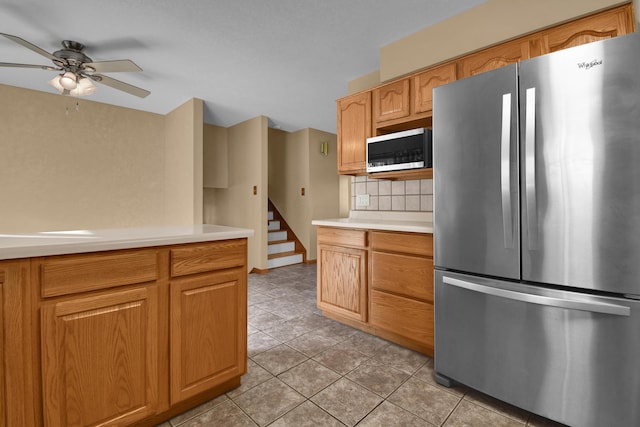 kitchen featuring tasteful backsplash, ceiling fan, stainless steel fridge, and light tile patterned flooring