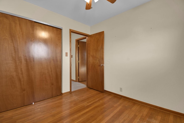 unfurnished bedroom featuring light hardwood / wood-style floors, a closet, and ceiling fan