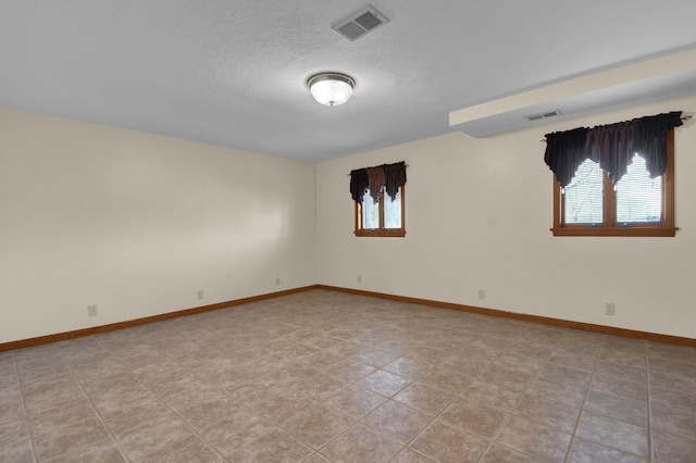 spare room featuring a healthy amount of sunlight and a textured ceiling