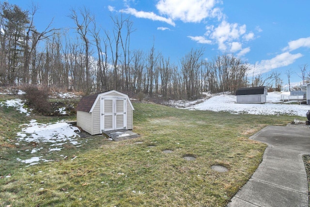 yard covered in snow featuring a storage unit