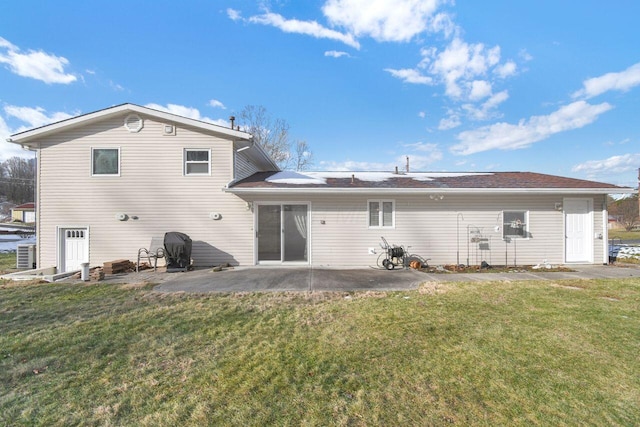 back of property with a lawn and a patio area