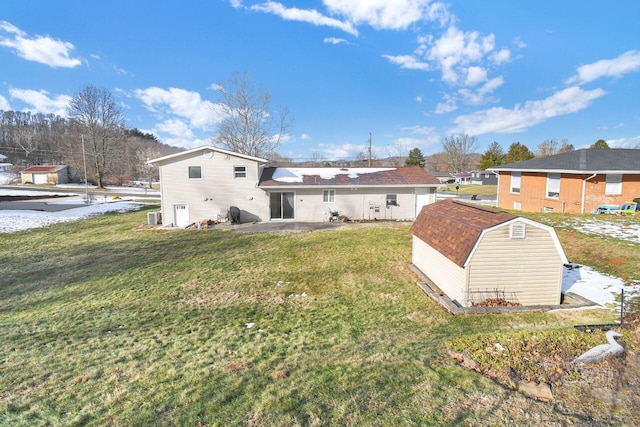 rear view of house with a yard, a patio area, and a storage unit