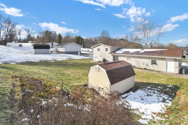 snowy yard with a storage shed