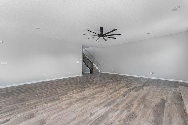 unfurnished living room featuring ceiling fan, hardwood / wood-style floors, and a textured ceiling