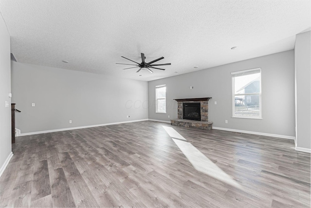 unfurnished living room featuring a fireplace, light hardwood / wood-style flooring, and a textured ceiling