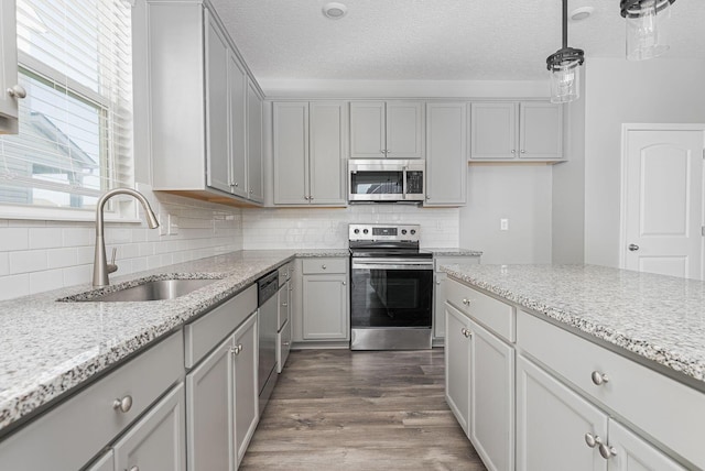 kitchen featuring gray cabinets, appliances with stainless steel finishes, sink, and pendant lighting